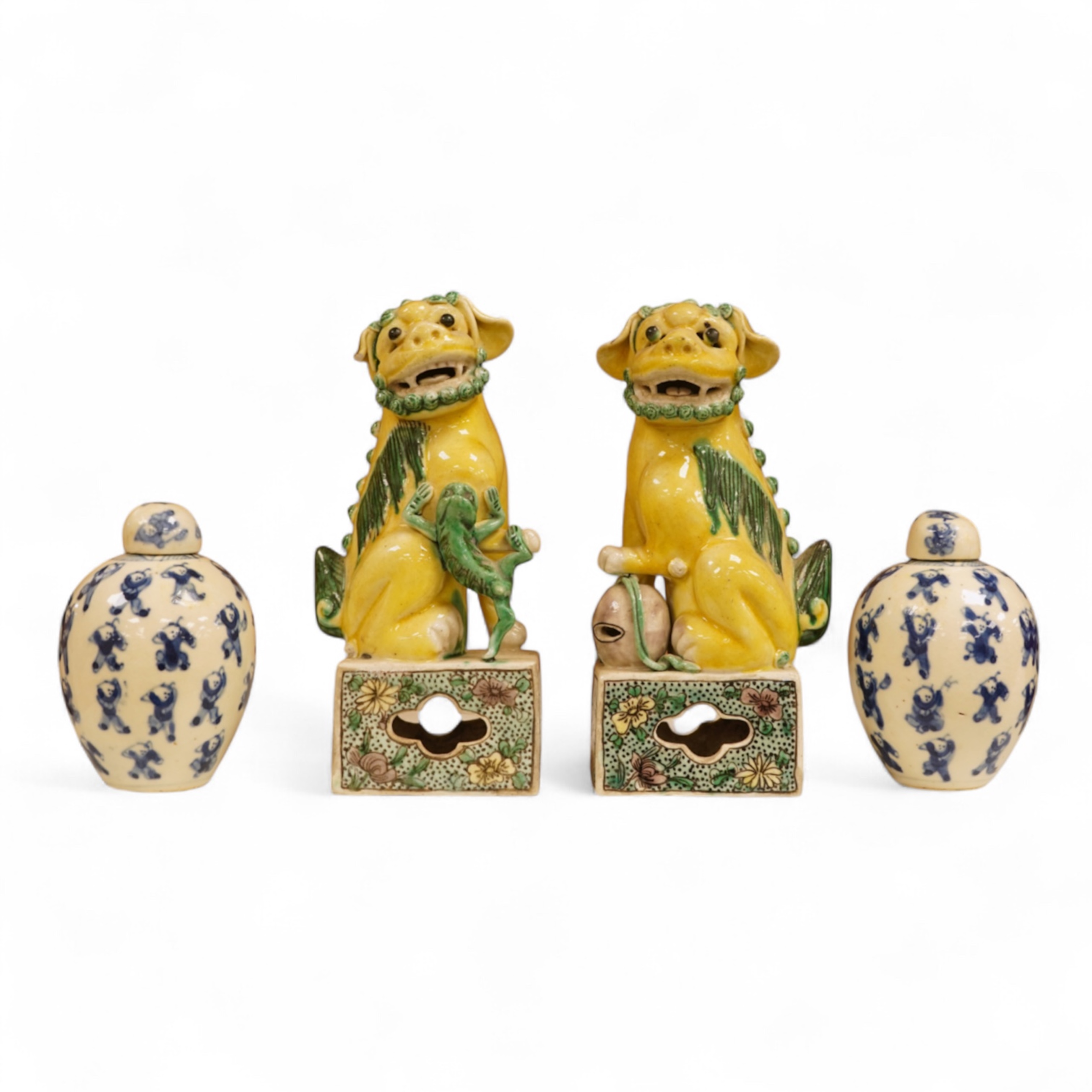A pair of late 19th/early 20th century Chinese famille verte lion dogs and a similar pair of blue and white miniature ‘boys’ jars and covers, 15cm